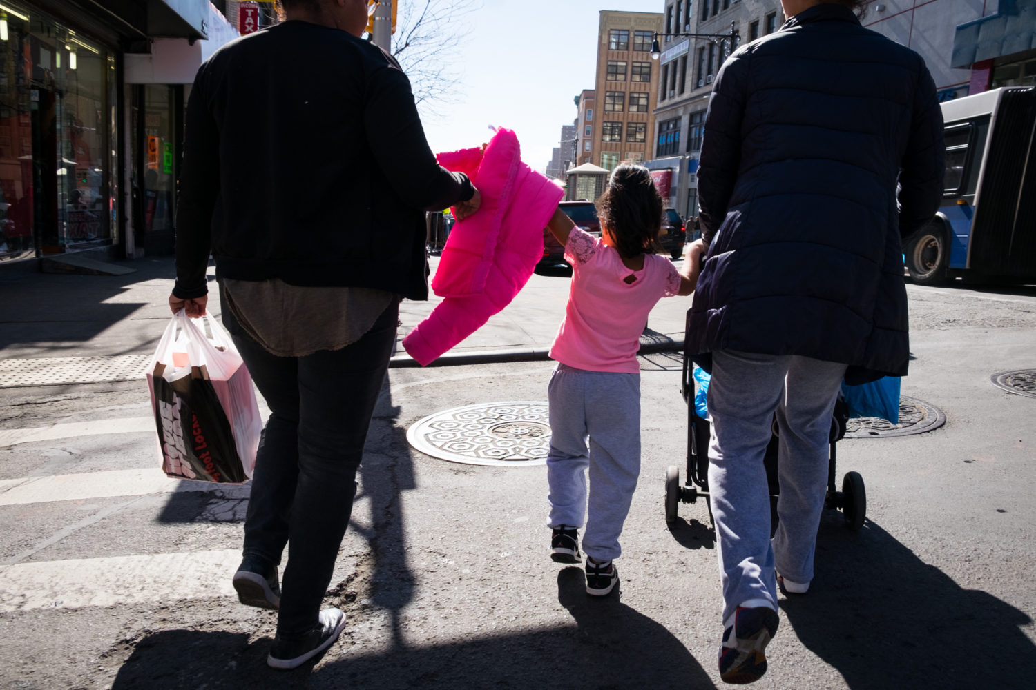 Little girl in pink walks in NYC with two women