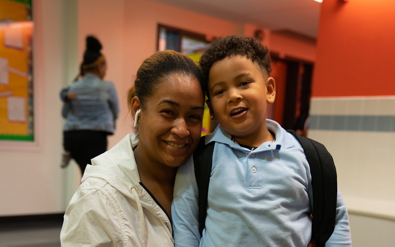 Mother and child smile together at a school